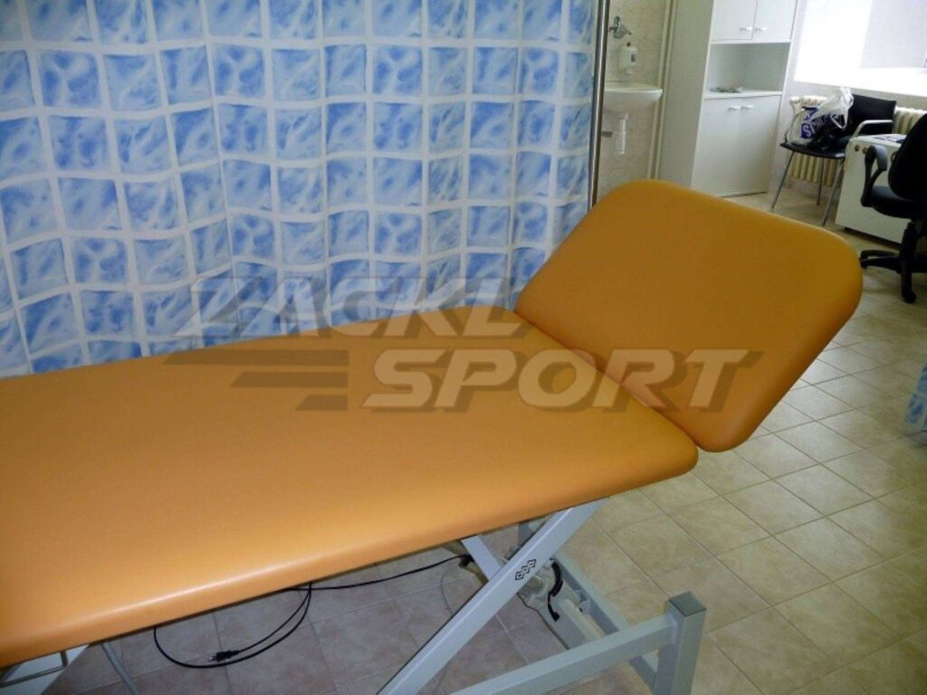 Nastavitelné rehabilitační lehátko s oranžovým čalouněním v ordinaci.