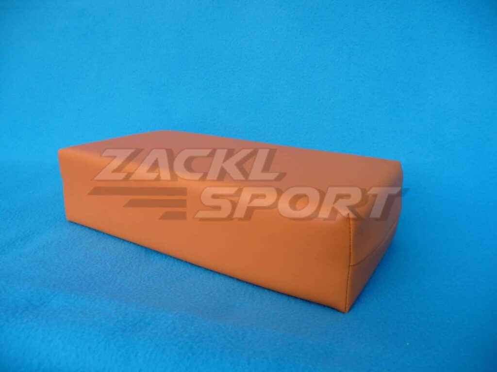 Hranatý blok z oranžového molitanu, ideální pro podporu končetin.